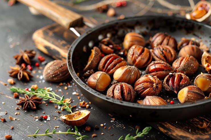 a pan of roasted chestnuts with a wooden spoon and a wooden spoon
