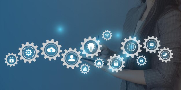 A woman is working with gears and icons of business people