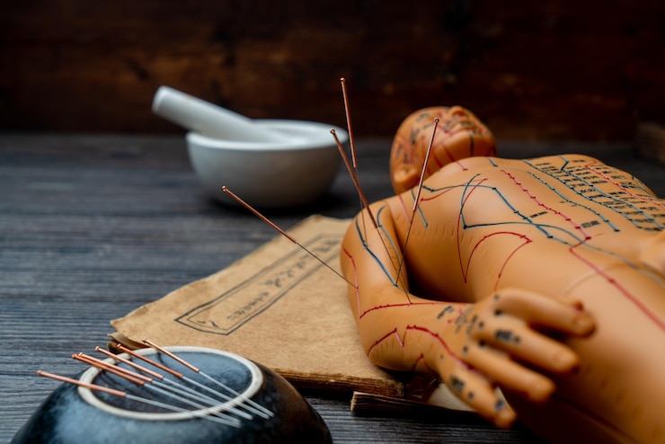 Fotoğraf acupuncture models and medical books are on the table. acupuncture is a traditional chinese medical method