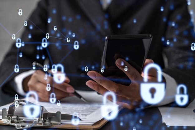 African American businesswoman in formal wear signing the contract to prevent probability of risks in cyber security Checking the phone Padlock Hologram icons over the working desk