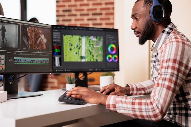 African american filmmaker editing audio film montage on professional software computer at home, using visual effects to create multimedia content. Post production footage with sound.