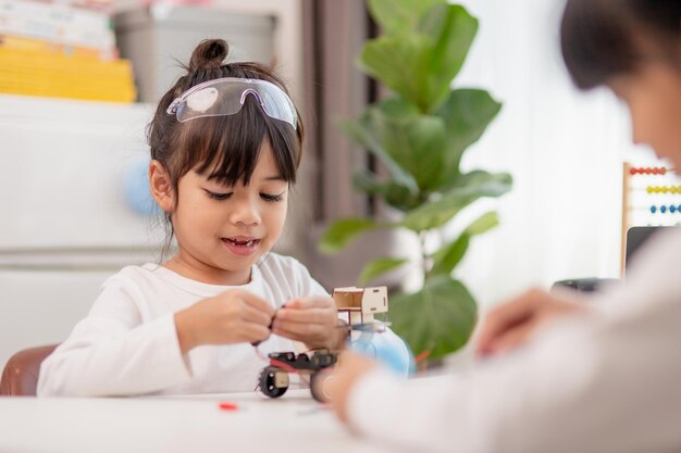 Asia students learn at home in coding robot cars and electronic board cables in STEM STEAM mathematics engineering science technology computer code in robotics for kids concept