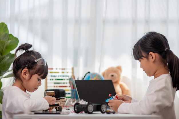 Asia students learn at home in coding robot cars and electronic board cables in STEM STEAM mathematics engineering science technology computer code in robotics for kids concept