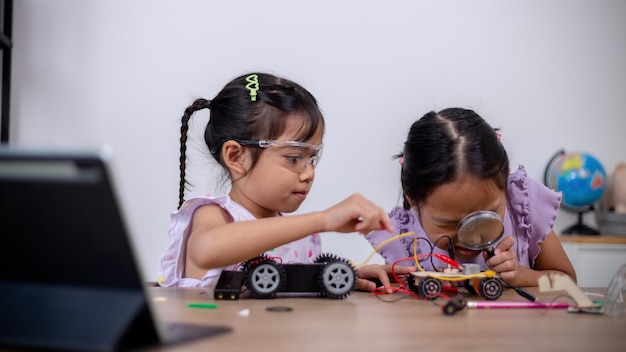 asian students learn at home by coding robot cars and electronic board cables in stem steam mathematics engineering science technology computer code in robotics for kids' concepts