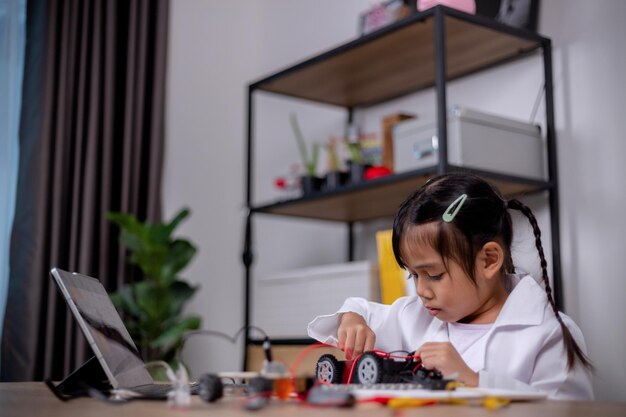 asian students learn at home by coding robot cars and electronic board cables in stem steam mathematics engineering science technology computer code in robotics for kids' concepts