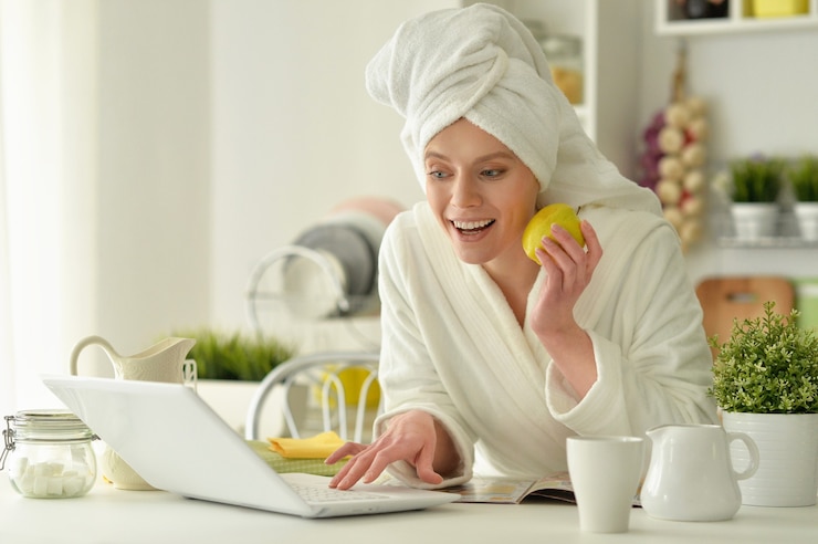 Fotoğraf beautiful young woman wearing a white bathrobe with laptop