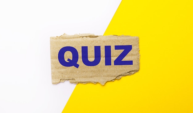 Beyaz ve sarı bir arka planda, QUIZ yazılı kahverengi yırtık karton