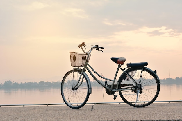 Bicycle by sea against sky during sunset