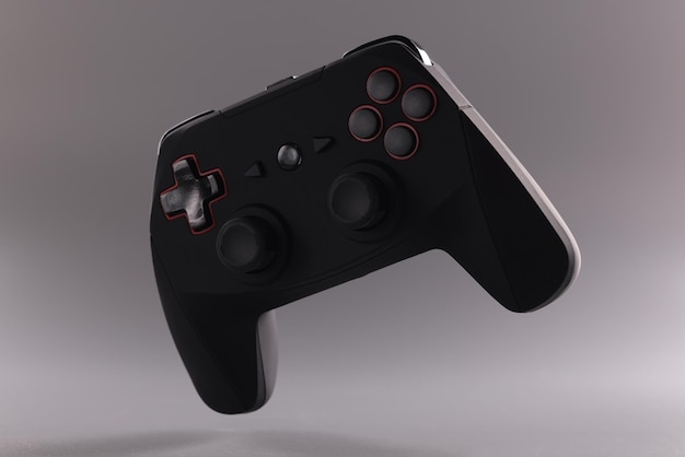 Black video game joystick or gamepad floating in air