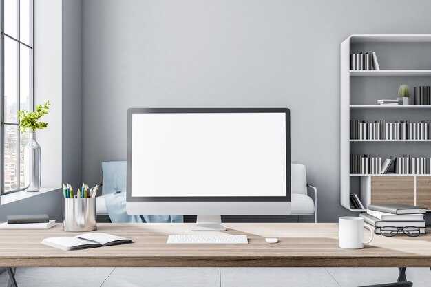 Blank white computer monitor on eco style wooden workspace table in sunny light room with huge window and white sofa on background 3D rendering mockup