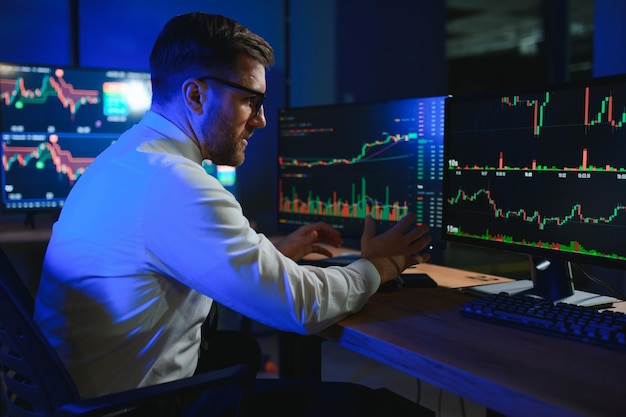 businessman comparing stock market data late in the evening