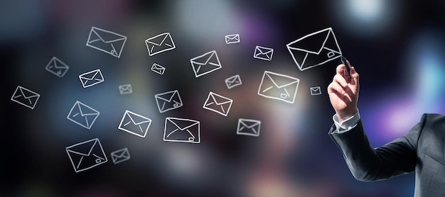 Businessman drawing envelopes on blurry dark background Email network and mobile marketing concept