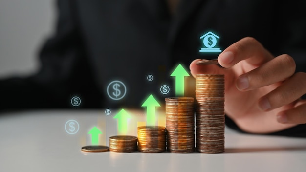 Businessman hand stacking coins with heights up arrow icons Income Management and saving money concepts