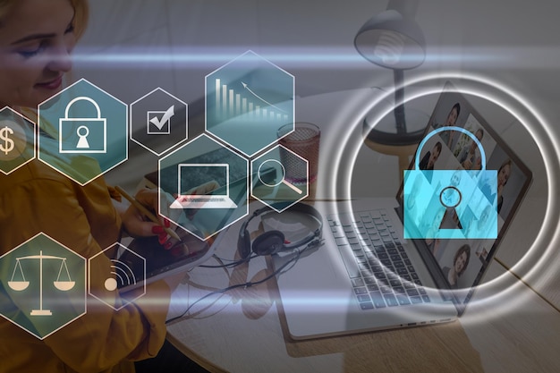 businesswoman with laptop, desktop at office interior, blue glowing information protection icons. padlock and business data symbols. concept of cyber security and data storage.