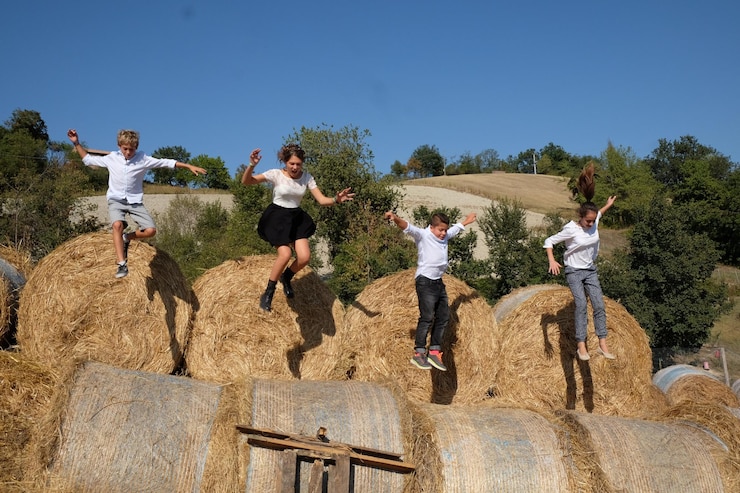 Fotoğraf children jumping on hay bales