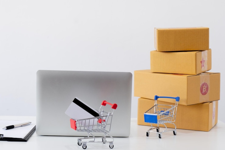 Fotoğraf close-up of laptop with cardboard boxes and shopping carts against gray background