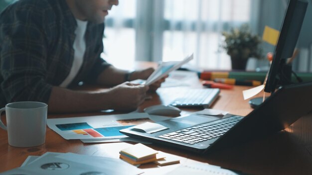 Close up of smart business man choosing house plan while sitting Symposium