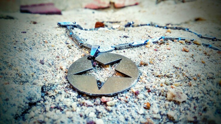 Fotoğraf close-up of star shape pendant on rock