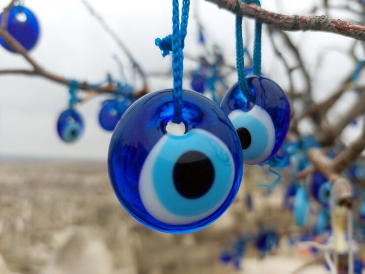 Fotoğraf closeup of tree with multiple blue evil eye charms hanging from it