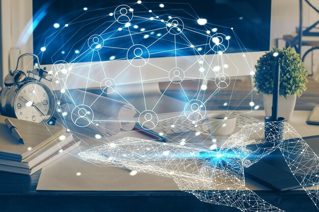 Computer on desktop with social network hologram Double exposure Concept of international people connections