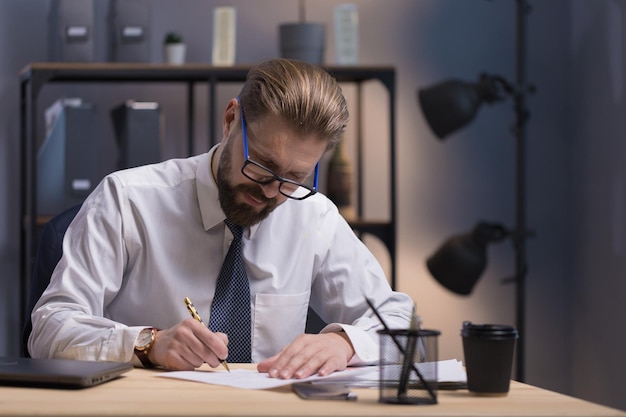 Concentrated Mature Bearded White Collar in Glasses Writing