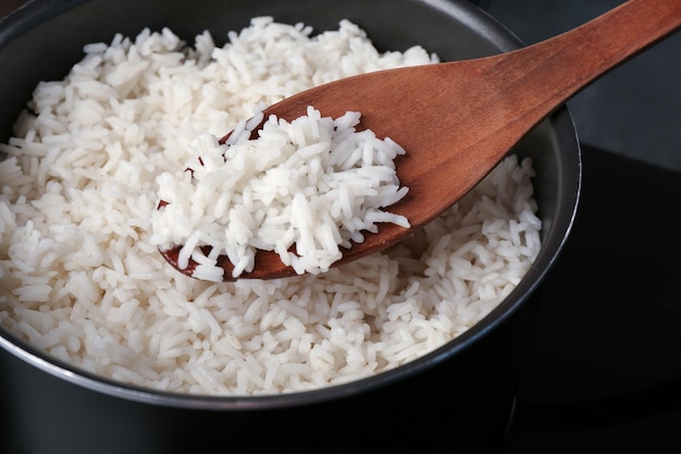 Cooked rice in saucepan with spoon