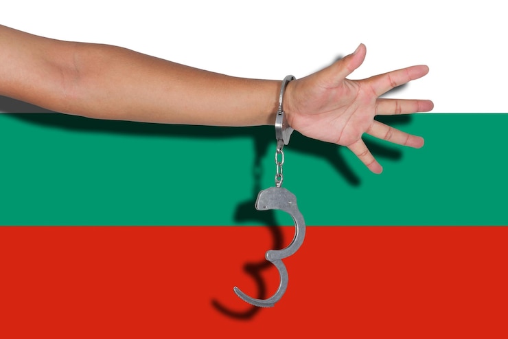 Fotoğraf cropped hand of person wearing handcuffs against flag