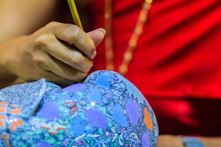 Fotoğraf cropped image of artist painting on ceramics