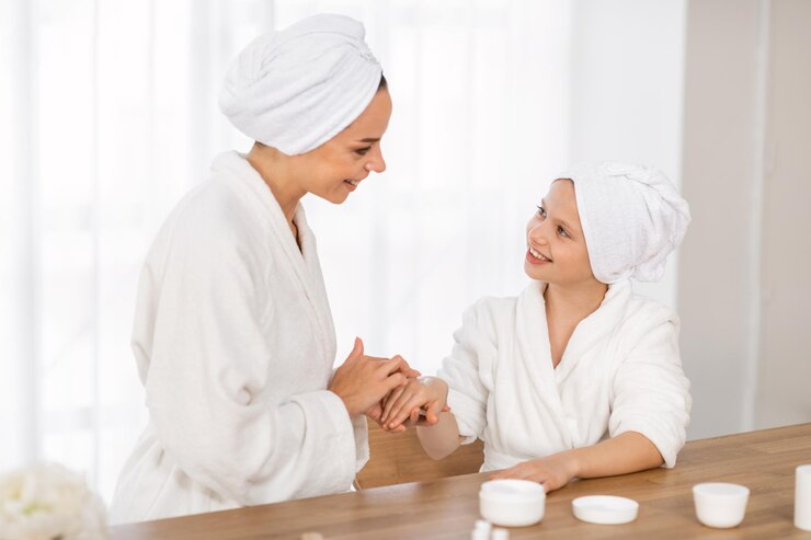 Fotoğraf cute little girl and her young mother having beauty day at home