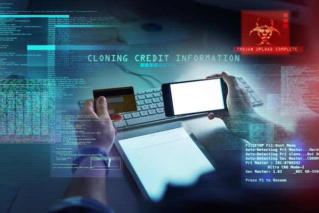 Cyber security hacking and fraud with a computer hacker holding a credit card and phone while cloning a bank account Theft crime and data protection with CGI special effects or overlay background