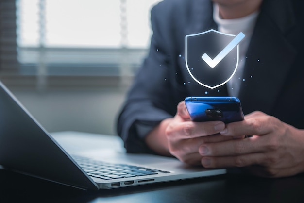 Data protection and network security concept Businessman using smartphone for log in with Shield and padlock networking connection insurance business internet fire wall and crime cyber protection
