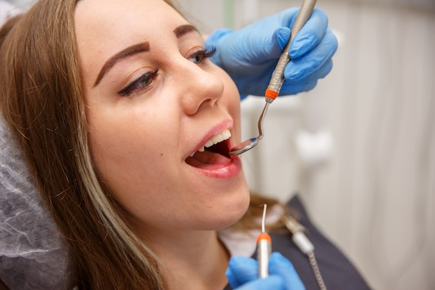 Dentist doctor treats the teeth of a young girl