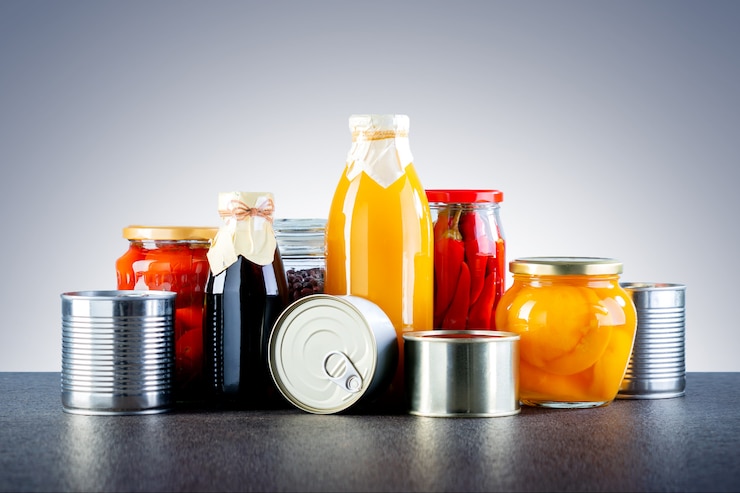 Fotoğraf different types of canned food. different glass jars with grains, pasta, vegetable, cans of canned food.