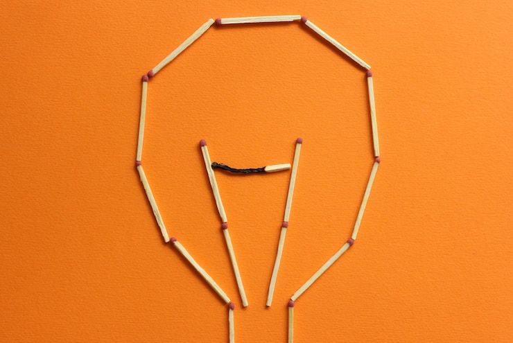 Fotoğraf directly above shot of matchsticks in lighting bulb shape orange background