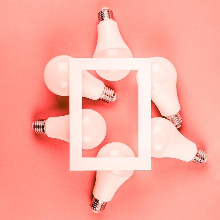 Fotoğraf directly above shot of picture frame over light bulbs against coral background