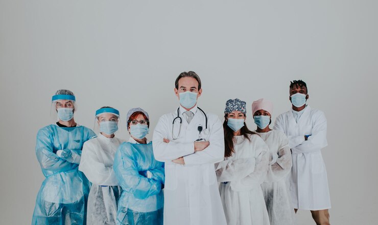 Fotoğraf doctors wearing mask standing against white background