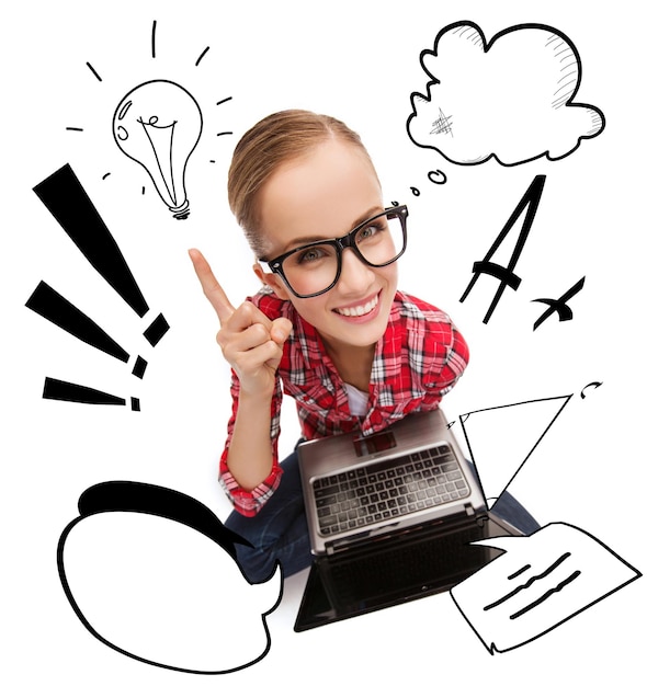 education, technology and internet concept - smiling teenage girl in black eyeglasses with laptop computer