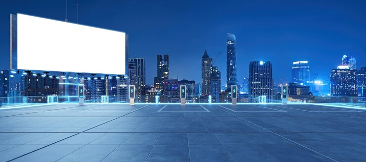 Electric vehicle charging stations illuminating a bangkok city car park at night with blank billboard