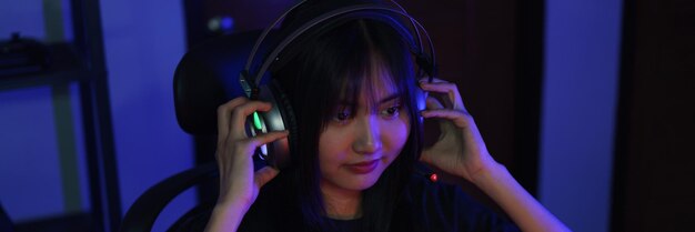 female cyber hacker gamer in headphone watching video game on monitor to hacking programming system