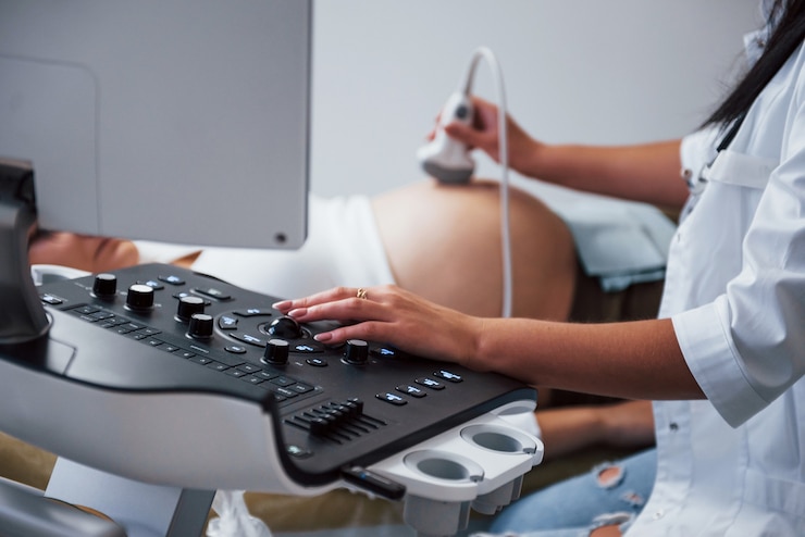 Fotoğraf female doctor does ultrasound for a pregnant woman in the hospital.