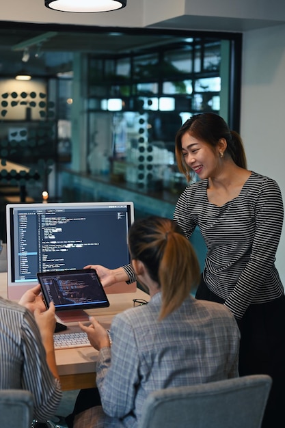 female project supervisor explaining detail of project developing website design and coding technologies at creative office