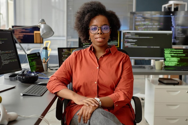 Female software developer in orange shirt at desk