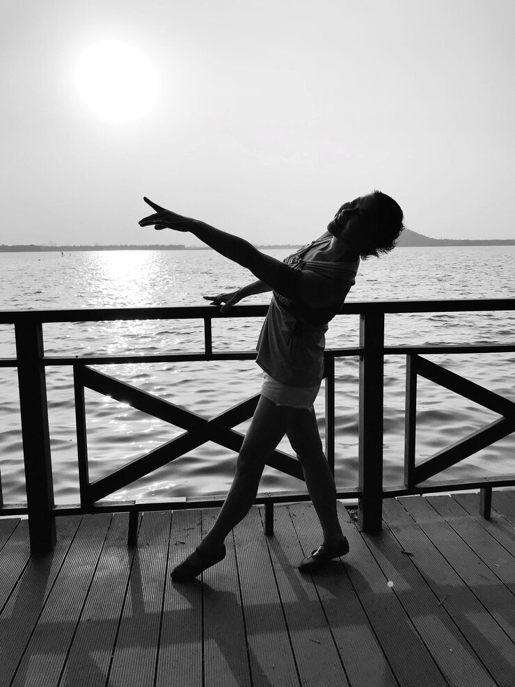 Fotoğraf full length of woman dancing by railing against sea