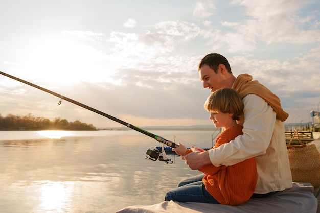 full shot father and son hanging out on a jetty