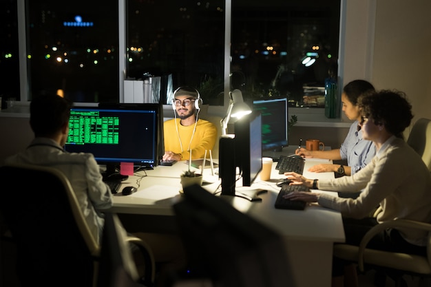 group of computer programmers coding at night