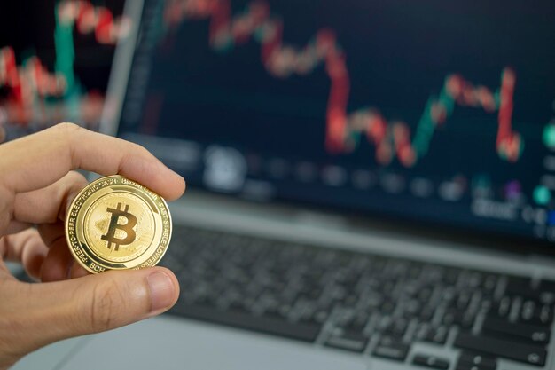 hand holding a coin Cryptocurrency Bitcoin on chart background Virtual cryptocurrency concept digital crypto currency for defi decentralized financial banking p2p exchange investment technology