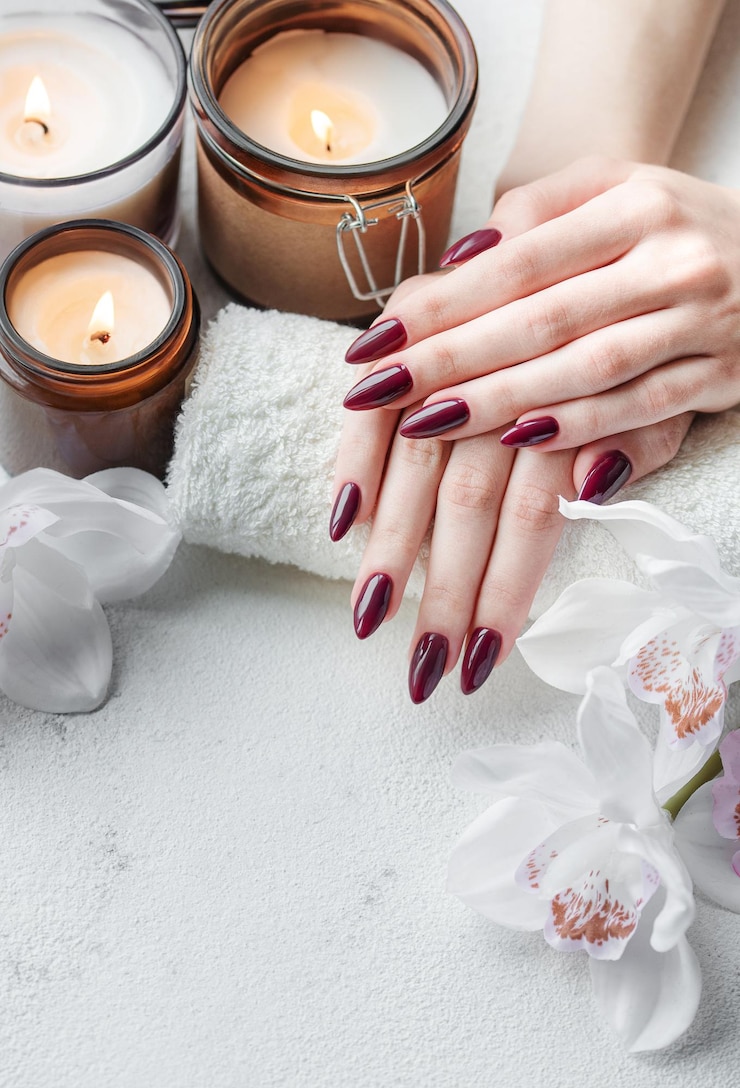 Fotoğraf hands of a young woman with dark red manicure on nails
