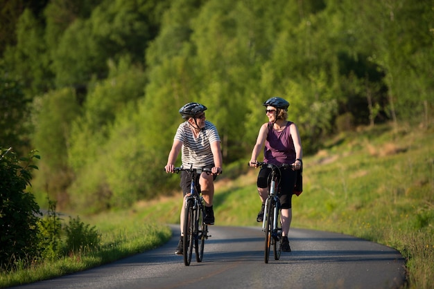 Happy couple riding bicycles on road