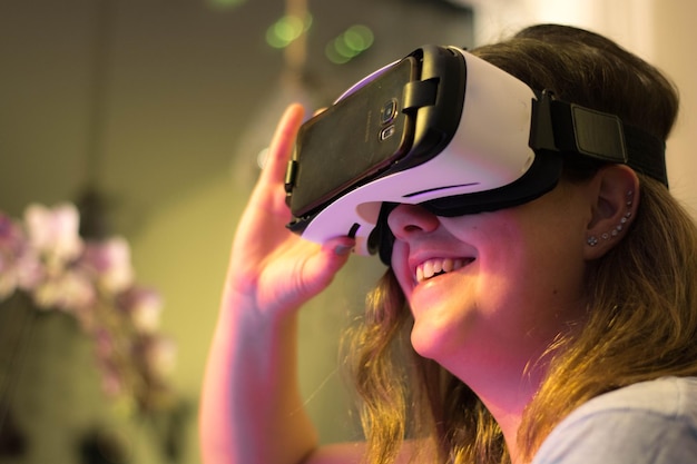 happy woman wearing virtual reality simulator in illuminated room