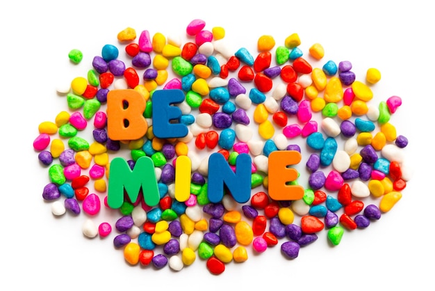 High angle view of colorful candies with be mine text over white background